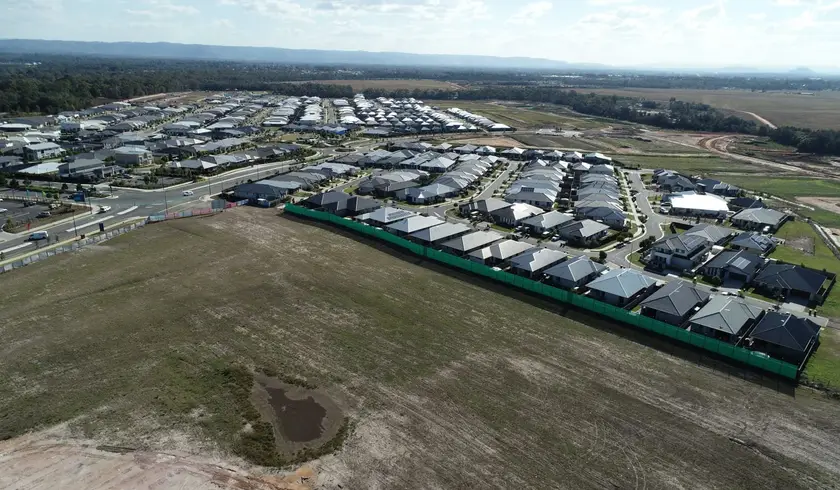 Cleared land for a new North Harbour stage beside established housing