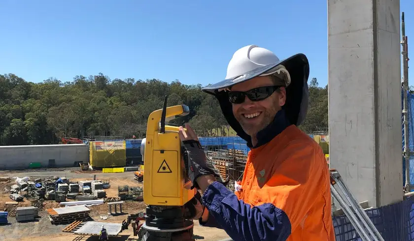 Surveyor with a total station overlooking the MILVEHCOE construction site