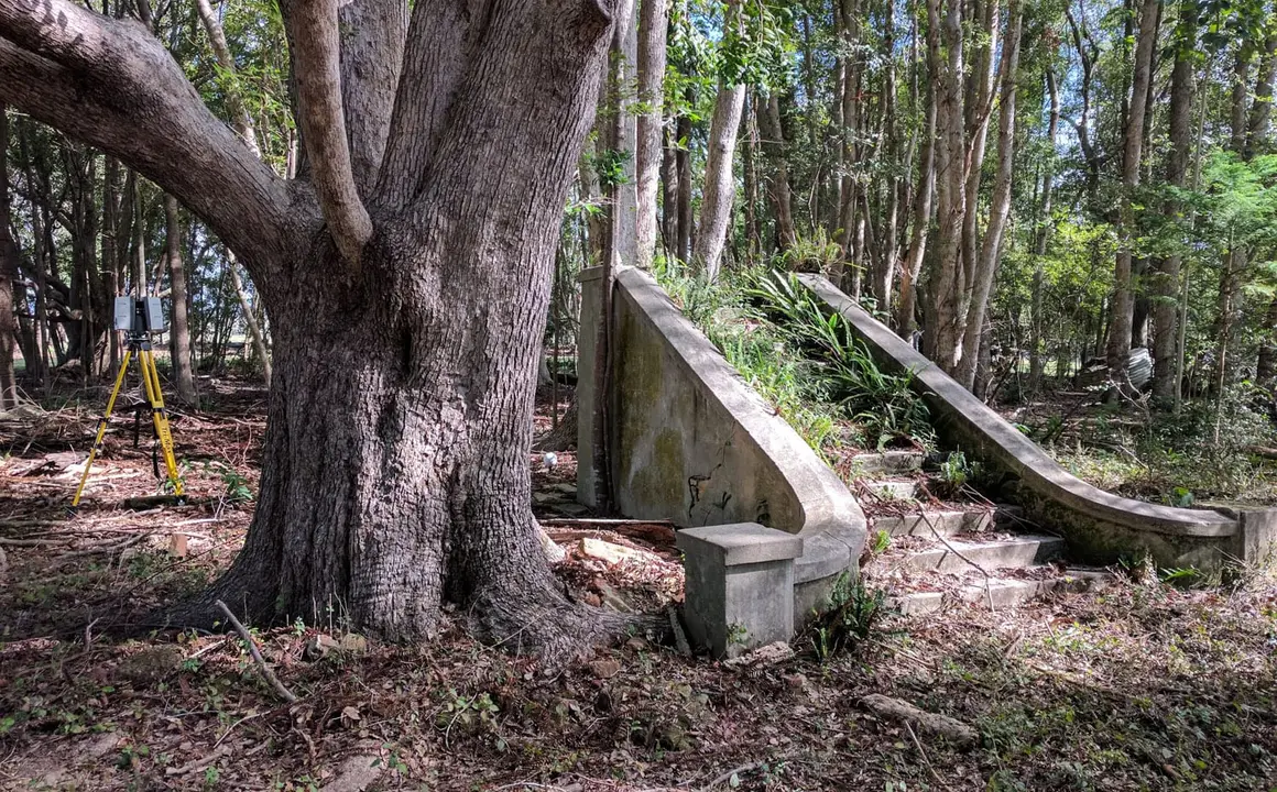 Heritage concrete staircase among the trees, with a laser scanner on a tripod behind