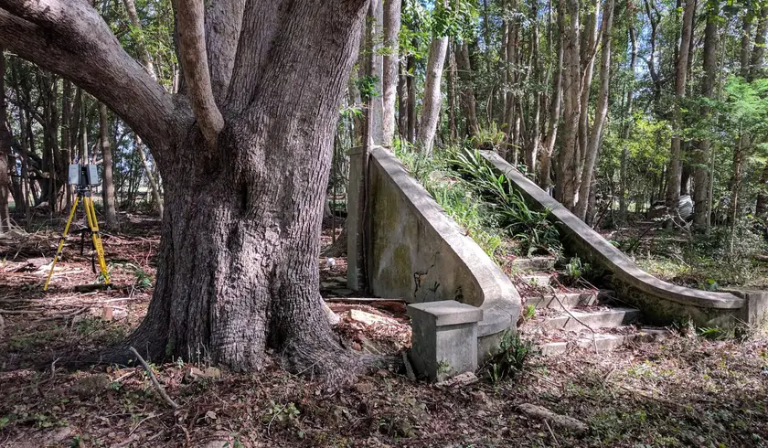 Heritage concrete staircase among the trees, with a laser scanner on a tripod behind
