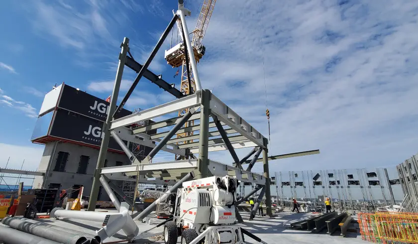 Rooftop steel exoskeleton frame being erected by crane at Jubilee Place