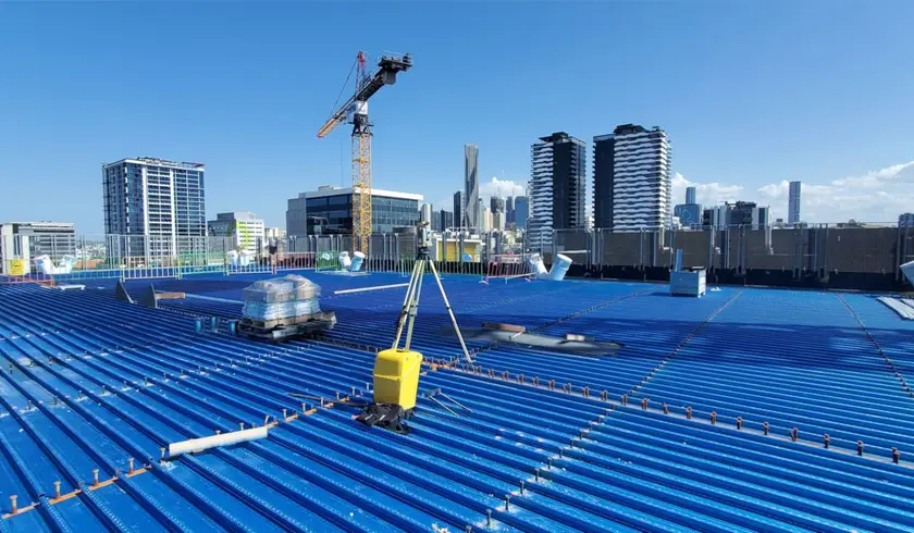 Total station set up on the steel deck of Jubilee Place, with the Brisbane skyline behind